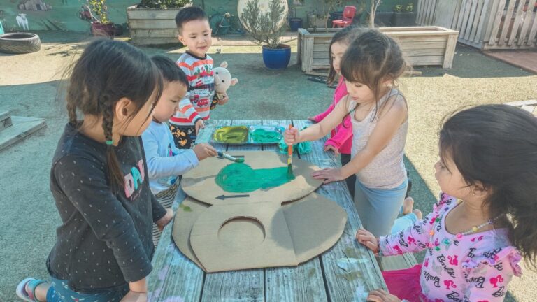 Tamariki painting outside at Early Learning Childcare Pukekohe and Botany